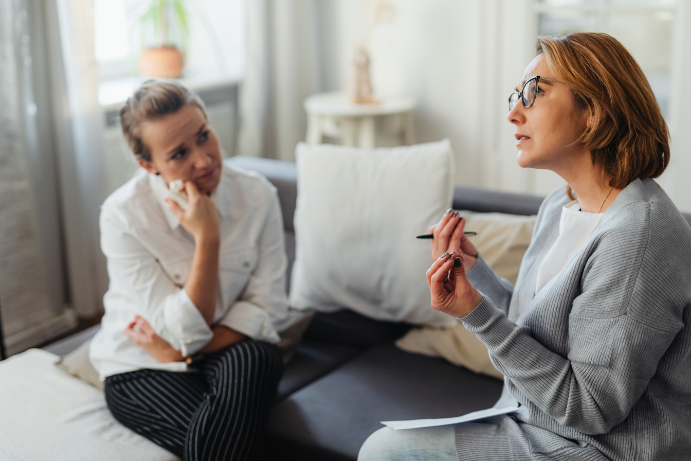 Woman in Gray Long Sleeves Wearing Black Framed Eyeglasses Talking to Woman in White Long Sleeves
